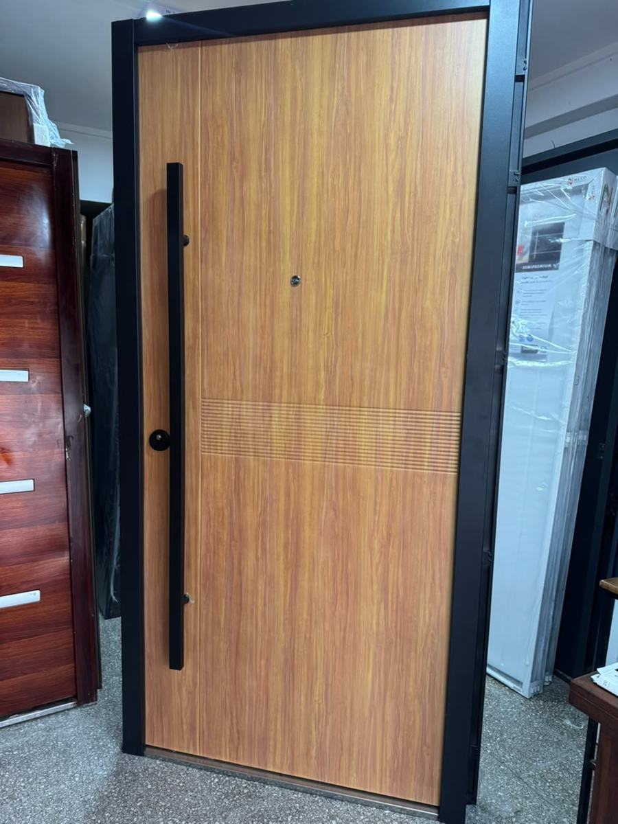 Puerta multianclaje en madera clara con marco negro y barral largo
